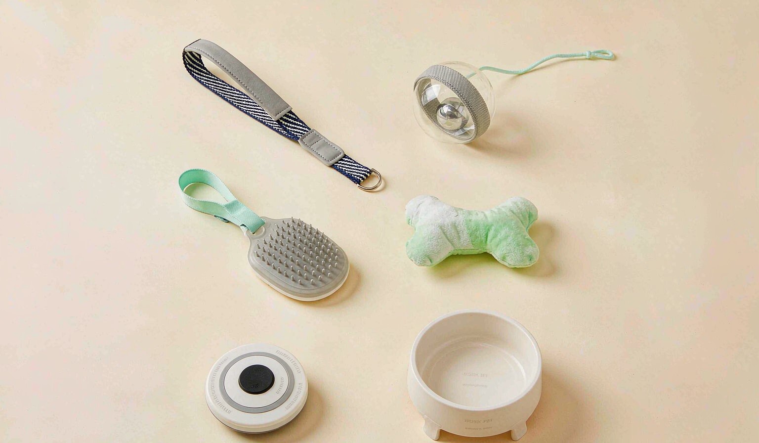 Neat grid of diverse pet products including cat toy, dog leash, grooming brush and pet bowl